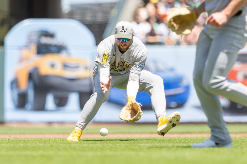 May 18, 2025; San Francisco, California, USA; Oakland Athletics third base Max Schuemann (12) makes a play on a ground ball during the first inning against the San Francisco Giants at Oracle Park. Mandatory Credit: Bob Kupbens-Imagn Images