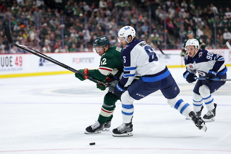 Sep 30, 2025; Saint Paul, Minnesota, USA; Minnesota Wild forward Matt Boldy (12) and Winnipeg Jets defenseman Colin Miller (6) compete for the puck during the second period at Grand Casino Arena. Mandatory Credit: Matt Krohn-Imagn Images