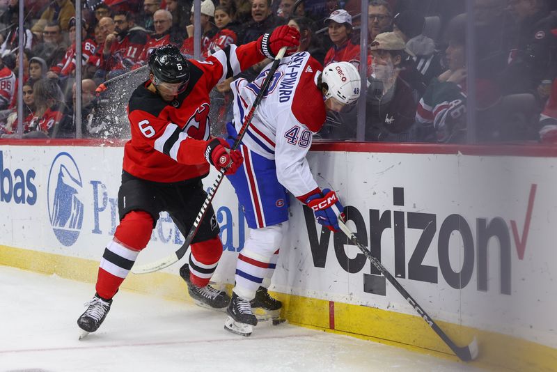 Jan 17, 2024; Newark, New Jersey, USA; New Jersey Devils defenseman John Marino (6) hits Montreal Canadiens left wing Rafael Harvey-Pinard (49) during the first period at Prudential Center. Mandatory Credit: Ed Mulholland-USA TODAY Sports