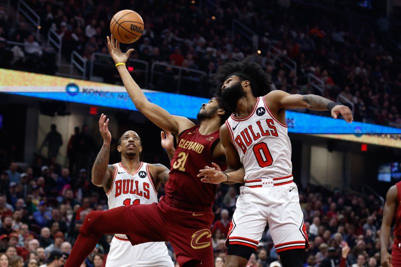 CLEVELAND, OH - FEBRUARY 14: Jarrett Allen #31 of the Cleveland Cavaliers rebounds between Coby White #0 and DeMar DeRozan #11 of the Chicago Bulls during the first half at Rocket Mortgage Fieldhouse on February 14, 2024 in Cleveland, Ohio. NOTE TO USER: User expressly acknowledges and agrees that, by downloading and or using this photograph, User is consenting to the terms and conditions of the Getty Images License Agreement. (Photo by Ron Schwane/Getty Images)