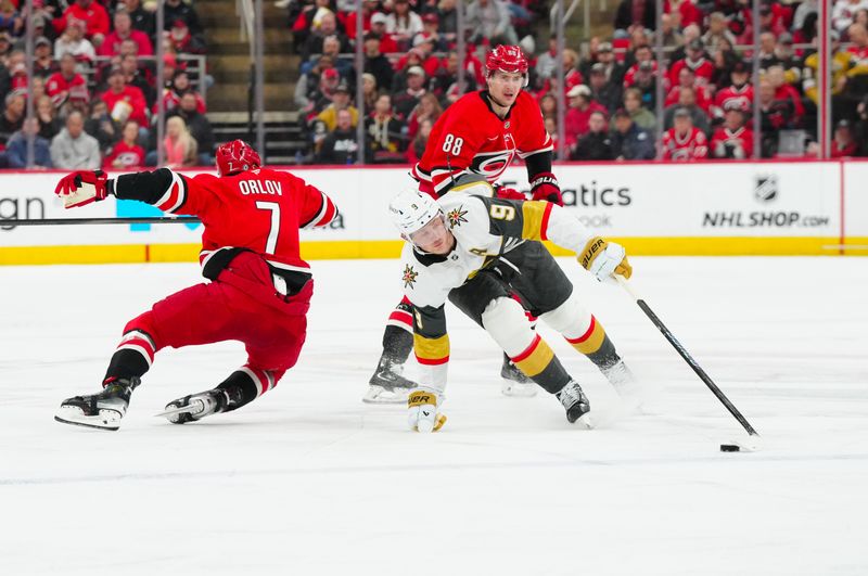 Jan 17, 2025; Raleigh, North Carolina, USA; Vegas Golden Knights center Jack Eichel (9) tries to get past the check by Carolina Hurricanes defenseman Dmitry Orlov (7) during the second period at Lenovo Center. Mandatory Credit: James Guillory-Imagn Images