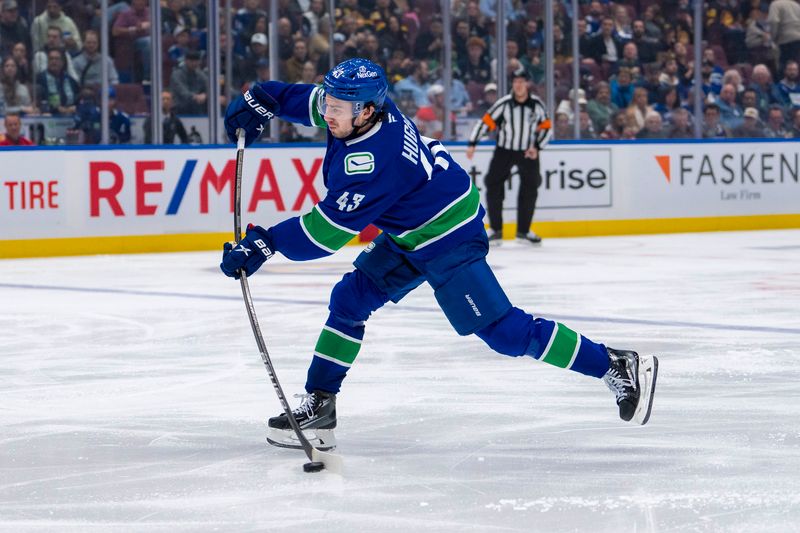 Oct 9, 2024; Vancouver, British Columbia, CAN; Vancouver Canucks defenseman Quinn Hughes (43) shoots against the Calgary Flames during the second period at Rogers Arena. Mandatory Credit: Bob Frid-Imagn Images