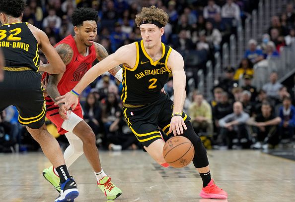 SAN FRANCISCO, CALIFORNIA - DECEMBER 23: Brandin Podziemski #2 of the Golden State Warriors dribbling the ball up court is guarded by Anfernee Simons #1 of the Portland Trail Blazers during the second half at Chase Center on December 23, 2023 in San Francisco, California. NOTE TO USER: User expressly acknowledges and agrees that, by downloading and or using this photograph, User is consenting to the terms and conditions of the Getty Images License Agreement. (Photo by Thearon W. Henderson/Getty Images)