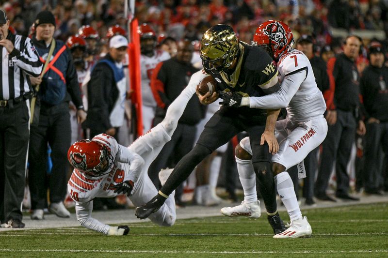 Nov 13, 2021; Winston-Salem, North Carolina, USA; Wake Forest Demon Deacons quarterback Sam Hartman (10) is tackled by North Carolina State Wolfpack cornerback Chris Ingram (7) during the second half at Truist Field. Mandatory Credit: William Howard-USA TODAY Sports