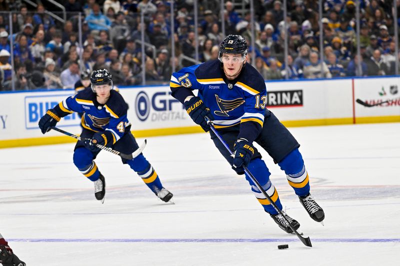 Dec 29, 2023; St. Louis, Missouri, USA;  St. Louis Blues right wing Alexey Toropchenko (13) controls the puck against the Colorado Avalanche during the second period at Enterprise Center. Mandatory Credit: Jeff Curry-USA TODAY Sports