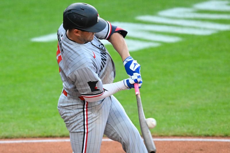 Apr 28, 2025; Cleveland, Ohio, USA; Minnesota Twins third baseman Jonah Bride (31) hits an infield single in the third inning against the Cleveland Guardians at Progressive Field. Mandatory Credit: David Richard-Imagn Images