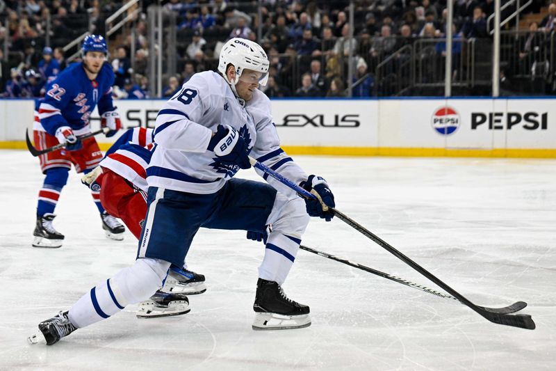 Mar 20, 2025; New York, New York, USA;  Toronto Maple Leafs center Steven Lorentz (18) attempts a back hand shot defended by New York Rangers defenseman Zac Jones (6) during the third period at Madison Square Garden. Mandatory Credit: Dennis Schneidler-Imagn Images