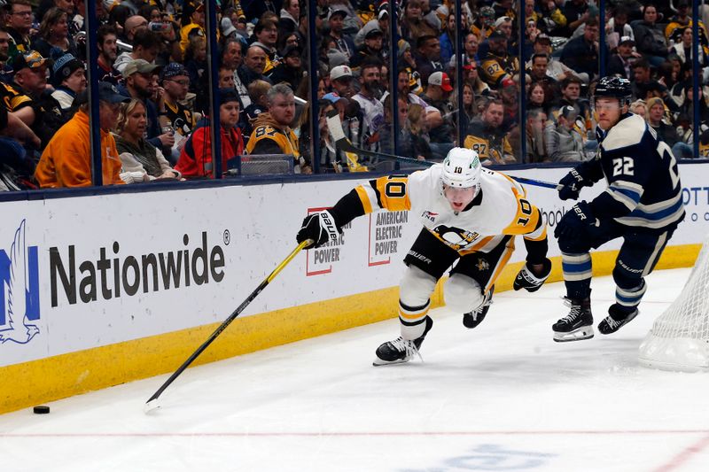 Nov 15, 2024; Columbus, Ohio, USA; Pittsburgh Penguins left wing Drew O'Connor (10) and Columbus Blue Jackets defenseman Jordan Harris (22) skate after a loose puck during the third period at Nationwide Arena. Mandatory Credit: Russell LaBounty-Imagn Images