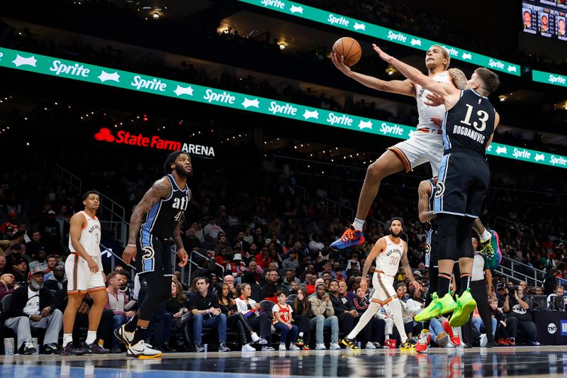 ATLANTA, GEORGIA - JANUARY 15: Jeremy Sochan #10 of the San Antonio Spurs scores over Bogdan Bogdanovic #13 of the Atlanta Hawks during the second half at State Farm Arena on January 15, 2024 in Atlanta, Georgia. NOTE TO USER: User expressly acknowledges and agrees that, by downloading and or using this photograph, User is consenting to the terms and conditions of the Getty Images License Agreement. (Photo by Alex Slitz/Getty Images)