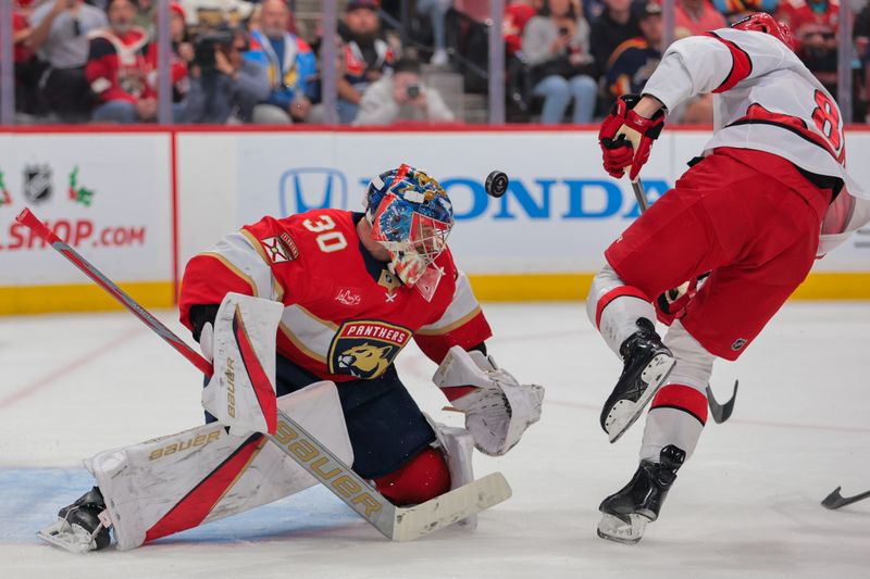 Nov 30, 2024; Sunrise, Florida, USA; Florida Panthers goaltender Spencer Knight (30) makes a save against Carolina Hurricanes center Martin Necas (88) during the first period at Amerant Bank Arena. Mandatory Credit: Sam Navarro-Imagn Images
