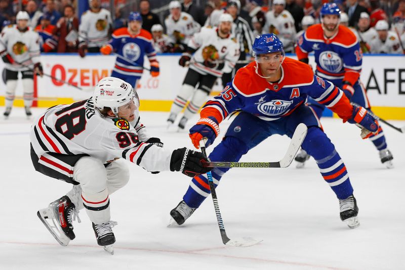 Oct 12, 2024; Edmonton, Alberta, CAN; Chicago Blackhawks forward Connor Bedard (98) gets a shot away in front of Edmonton Oilers defensemen Darnell Nurse (25) during the second period at Rogers Place. Mandatory Credit: Perry Nelson-Imagn Images