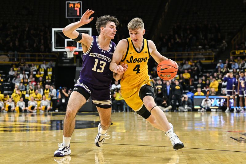 Dec 3, 2024; Iowa City, Iowa, USA; Iowa Hawkeyes guard Josh Dix (4) controls the ball as Northwestern Wildcats guard Brooks Barnhizer (13) defends during the second half at Carver-Hawkeye Arena. Mandatory Credit: Jeffrey Becker-Imagn Images