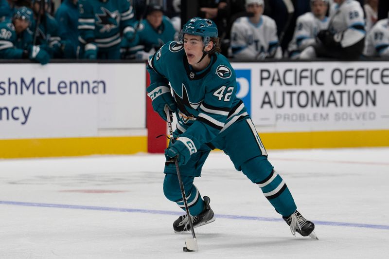 Oct 1, 2024; San Jose, California, USA;  San Jose Sharks defenseman Luca Cagnoni (42) controls the puck during the second period against the Utah Hockey Club at SAP Center at San Jose. Mandatory Credit: Stan Szeto-Imagn Images
