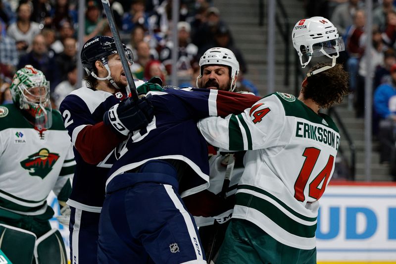 Apr 9, 2024; Denver, Colorado, USA; Colorado Avalanche center Ross Colton (20) knocks the helmet off of Minnesota Wild center Joel Eriksson Ek (14) as right wing Brandon Duhaime (12) and defenseman Zach Bogosian (24) look on in the second period at Ball Arena. Mandatory Credit: Isaiah J. Downing-USA TODAY Sports