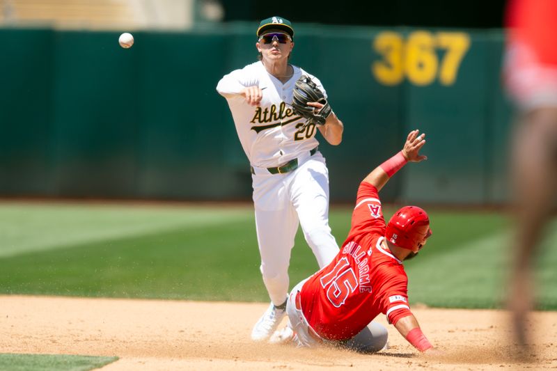 Jul 20, 2024; Oakland, California, USA; Oakland Athletics second baseman Zack Gelof (20) throws over Los Angeles Angels second baseman Luis Guillorme (15) to complete a double play during the fifth inning at Oakland-Alameda County Coliseum. Mandatory Credit: D. Ross Cameron-USA TODAY Sports