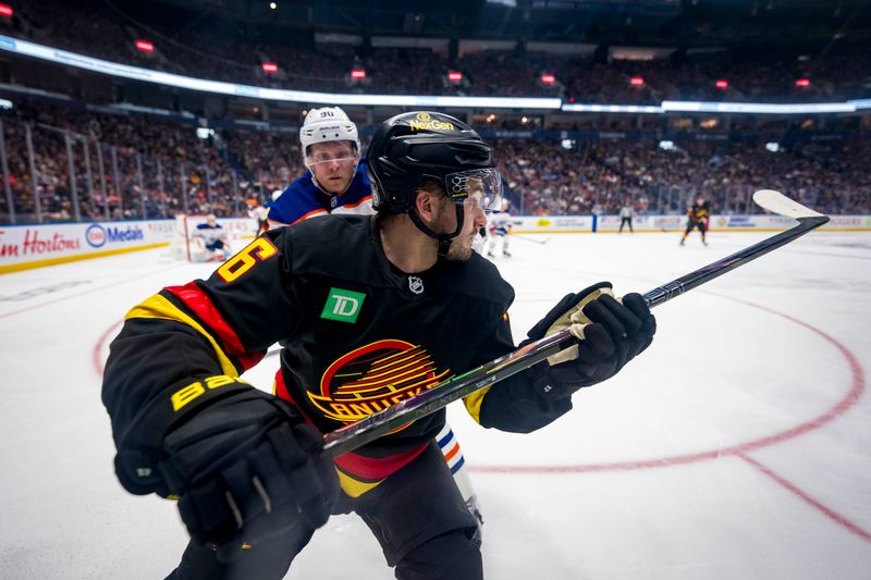 Nov 9, 2024; Vancouver, British Columbia, CAN; Edmonton Oilers forward Corey Perry (90) checks Vancouver Canucks defenseman Erik Brannstrom (26) during the second period at Rogers Arena. Mandatory Credit: Bob Frid-Imagn Images