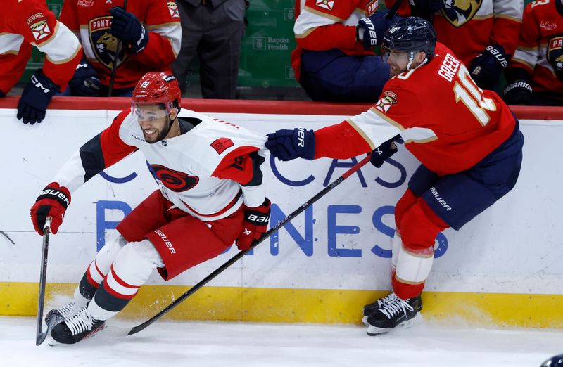 Dec 19, 2025; Sunrise, Florida, USA;  Florida Panthers left wing A.J. Greer (10) pulls the jersey of Carolina Hurricanes defenseman K'Andre Miller (19)during the second period at Amerant Bank Arena. Mandatory Credit: Rhona Wise-Imagn Images