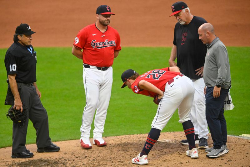 Jul 24, 2024; Cleveland, Ohio, USA; Cleveland Guardians starting pitcher Tanner Bibee (28) stretches beside manager Stephen Vogt (12) and pitching coach Carl Willis (51) before leaving the game in the fifth inning against the Detroit Tigers at Progressive Field. Mandatory Credit: David Richard-USA TODAY Sports