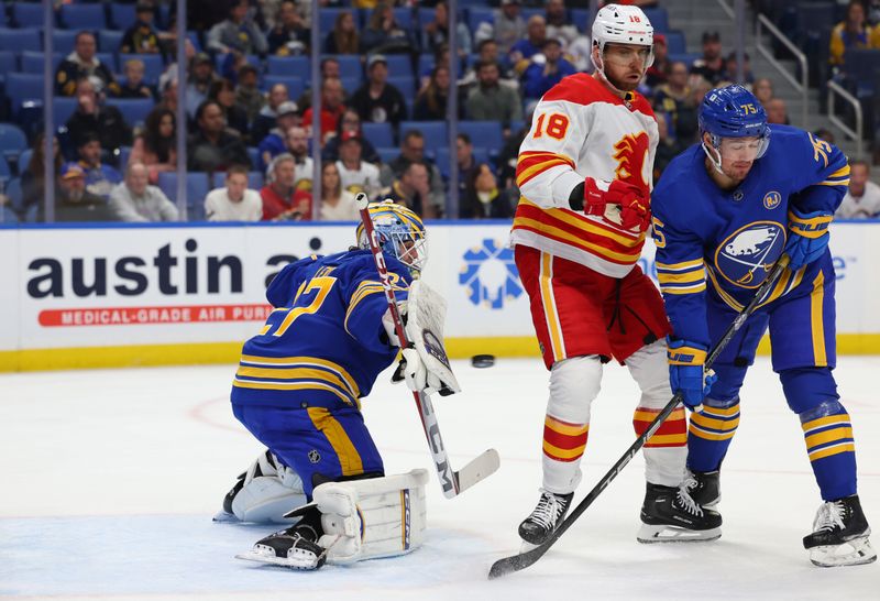 Oct 19, 2023; Buffalo, New York, USA;  Calgary Flames left wing A.J. Greer (18) and Buffalo Sabres defenseman Connor Clifton (75) stand in front of Buffalo Sabres goaltender Devon Levi (27) as he looks to make a save during the first period at KeyBank Center. Mandatory Credit: Timothy T. Ludwig-USA TODAY Sports