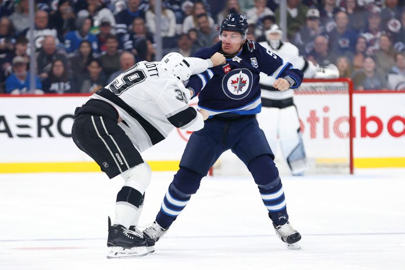 Oct 11, 2025; Winnipeg, Manitoba, CAN; Los Angeles Kings left wing Jeff Malott (39) and Winnipeg Jets defenseman Luke Schenn (5) fight during the first period at Canada Life Centre. Mandatory Credit: James Carey Lauder-Imagn Images