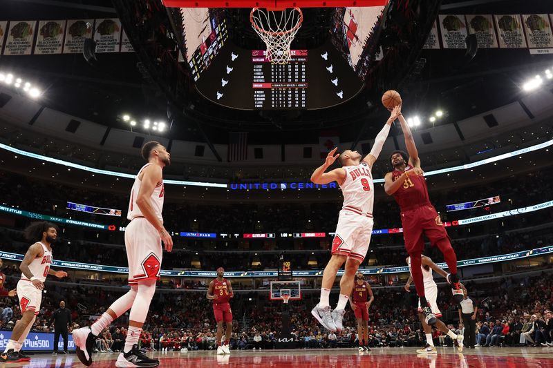 CHICAGO, ILLINOIS - OCTOBER 18: Jarrett Allen #31 of the Cleveland Cavaliers shoots over Nikola Vucevic #9 of the Chicago Bulls during the first half of a preseason game at the United Center on October 18, 2024 in Chicago, Illinois. NOTE TO USER: User expressly acknowledges and agrees that, by downloading and or using this photograph, User is consenting to the terms and conditions of the Getty Images License Agreement.  (Photo by Michael Reaves/Getty Images)