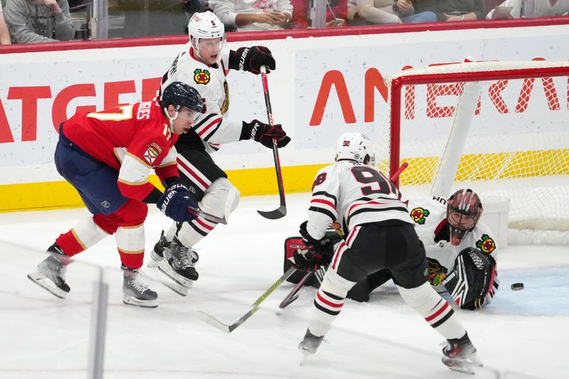 Nov 12, 2023; Sunrise, Florida, USA; Chicago Blackhawks goaltender Arvid Soderblom (40) deflects the shot of Florida Panthers center Evan Rodrigues (17) during the third period at Amerant Bank Arena. Mandatory Credit: Jasen Vinlove-USA TODAY Sports