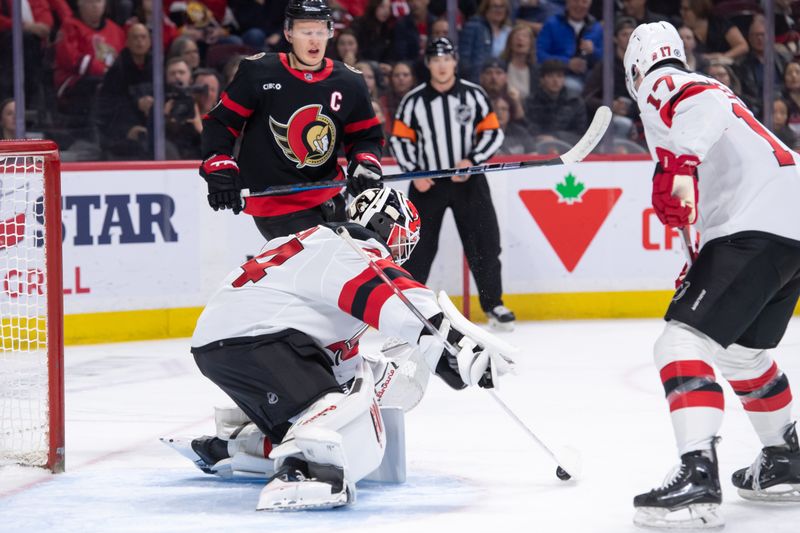 Apr 6, 2024; Ottawa, Ontario, CAN; New Jersey Devils goalie Jake Allen (34) makes a save as Ottawa Senators left wing Brady Tkachuk (7) looks on in the first period at the Canadian Tire Centre. Mandatory Credit: Marc DesRosiers-USA TODAY Sports