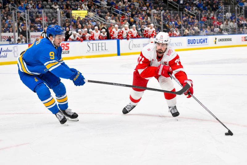 Oct 28, 2025; St. Louis, Missouri, USA; Detroit Red Wings center Dylan Larkin (71) controls the puck as St. Louis Blues left wing Alexandre Texier (9) defends during the third period at Enterprise Center. Mandatory Credit: Jeff Curry-Imagn Images