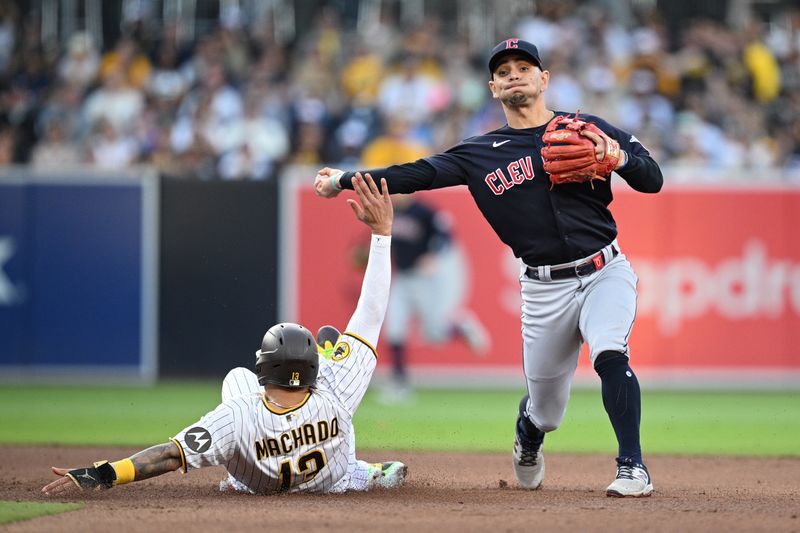 Jun 15, 2023; San Diego, California, USA; Cleveland Guardians second baseman Andres Gimenez (right) throws to first base after forcing out San Diego Padres third baseman Manny Machado (13) at second base to complete a double play during the fourth inning at Petco Park. Mandatory Credit: Orlando Ramirez-USA TODAY Sports