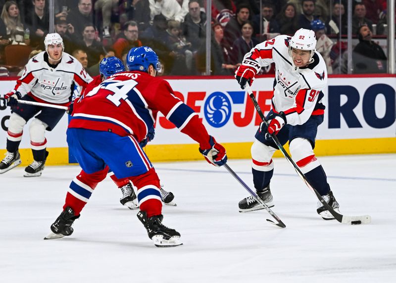 Oct 21, 2023; Montreal, Quebec, CAN; Washington Capitals center Evgeny Kuznetsov (92) plays the puck against Montreal Canadiens defenseman Jordan Harris (54) during the third period at Bell Centre. Mandatory Credit: David Kirouac-USA TODAY Sports