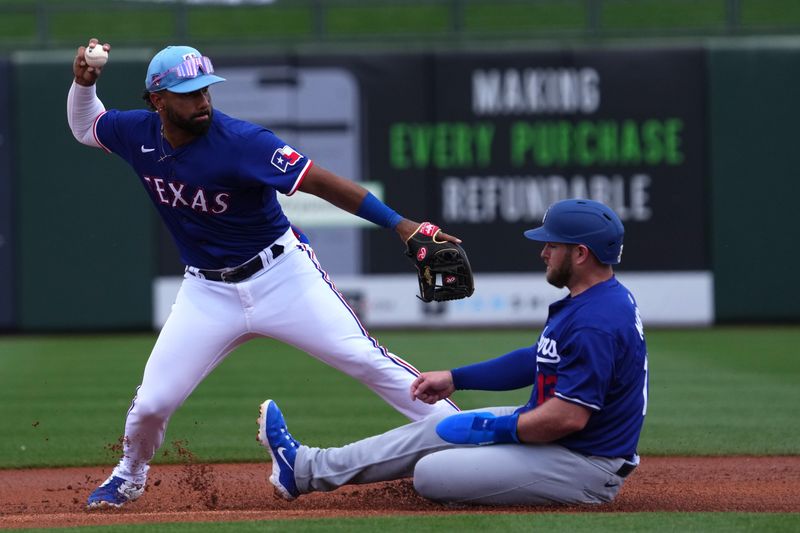 Feb 28, 2024; Surprise, Arizona, USA; Texas Rangers shortstop Ezequiel Duran (20) throws to first base after forcing out Los Angeles Dodgers third baseman Max Muncy (13) at second during the first inning at Surprise Stadium. Mandatory Credit: Joe Camporeale-USA TODAY Sports