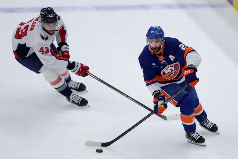 Oct 11, 2025; Elmont, New York, USA; New York Islanders center Kyle Palmieri (21) skates with the puck against Washington Capitals right wing Tom Wilson (43) during the first period at UBS Arena. Mandatory Credit: Brad Penner-Imagn Images