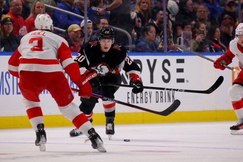 Oct 26, 2024; Buffalo, New York, USA;  Buffalo Sabres center Jiri Kulich (20) brings the [puck up ice as Detroit Red Wings defenseman Justin Holl (3) defends during the second period at KeyBank Center. Mandatory Credit: Timothy T. Ludwig-Imagn Images