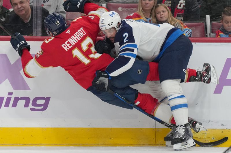 Nov 16, 2024; Sunrise, Florida, USA;  Winnipeg Jets defenseman Dylan DeMelo (2) takes down Florida Panthers center Sam Reinhart (13) during the first period at Amerant Bank Arena. Mandatory Credit: Jim Rassol-Imagn Images