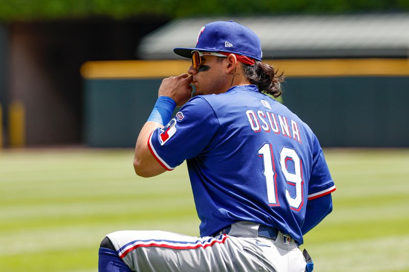 May 24, 2025; Chicago, Illinois, USA; Texas Rangers left fielder Alejandro Osuna (19) warms up before a baseball game against the Chicago White Sox at Rate Field. Mandatory Credit: Kamil Krzaczynski-Imagn Images