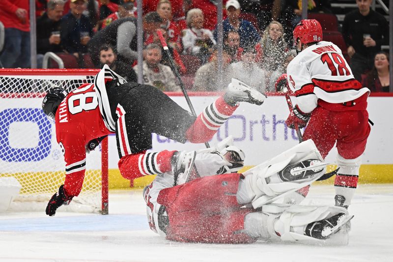 Apr 14, 2024; Chicago, Illinois, USA; Chicago Blackhawks forward Andreas Athanasiou (89) is tripped by Carolina Hurricanes goaltender Pyotr Kochetkov (52) in the third period at United Center. Mandatory Credit: Jamie Sabau-USA TODAY Sports