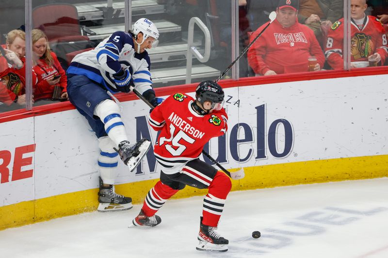 Feb 23, 2024; Chicago, Illinois, USA; Winnipeg Jets defenseman Brenden Dillon (5) battles for the puck with Chicago Blackhawks right wing Joey Anderson (15) during the first period at United Center. Mandatory Credit: Kamil Krzaczynski-USA TODAY Sports