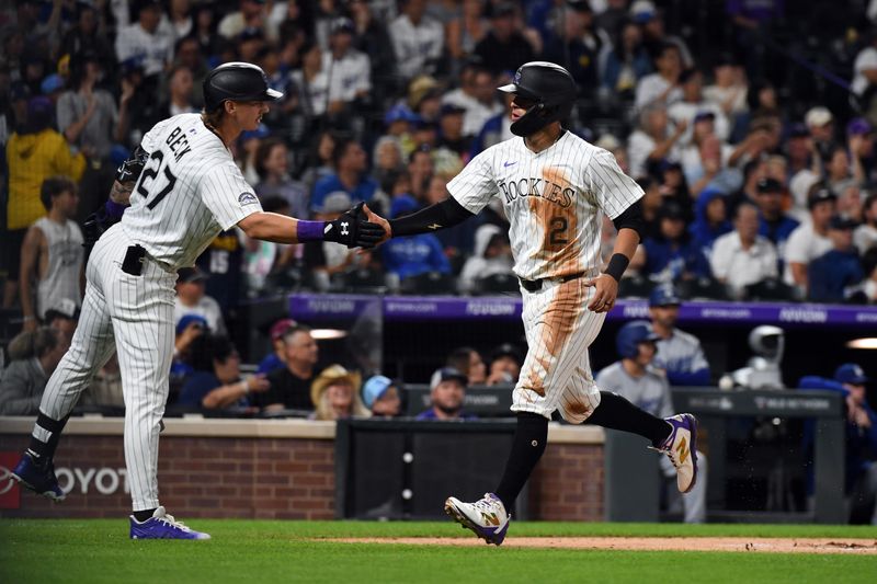 Jun 25, 2025; Denver, Colorado, USA; Colorado Rockies outfielder Tyler Freeman (2) is congratulated by outfielder Jordan Beck (27) after scoring during the sixth inning against the Los Angeles Dodgers at Coors Field. Mandatory Credit: Christopher Hanewinckel-Imagn Images