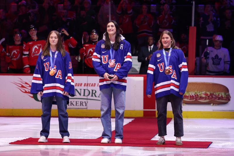 Mar 4, 2026; Newark, New Jersey, USA; (L to R) Aerin Frankel, Megan Keller and Haley Winn of the 2026 gold medal winning women’s Team USA are honored before the start of the NHL game between the New Jersey Devils and the Toronto Maple Leafs at Prudential Center.  Mandatory Credit: Ed Mulholland-Imagn Images