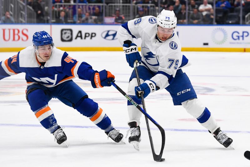 Apr 6, 2023; Elmont, New York, USA; Tampa Bay Lightning center Ross Colton (79) skates across the blue line defended by New York Islanders center Jean-Gabriel Pageau (44) during the first period at UBS Arena. Mandatory Credit: Dennis Schneidler-USA TODAY Sports