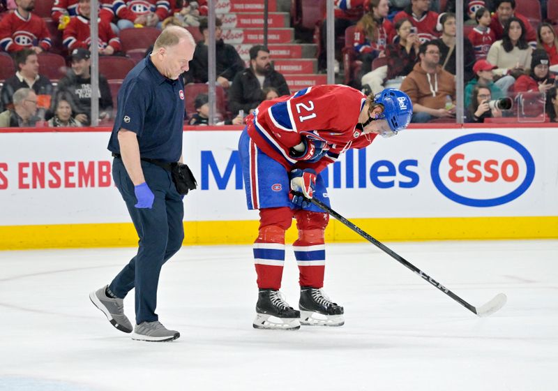 Feb 11, 2024; Montreal, Quebec, CAN; Montreal Canadiens defenseman Kaiden Guhle (21) leaves the ice with the help of a trainer during the third period of the game against the St.Louis Blues at the Bell Centre. Mandatory Credit: Eric Bolte-USA TODAY Sports