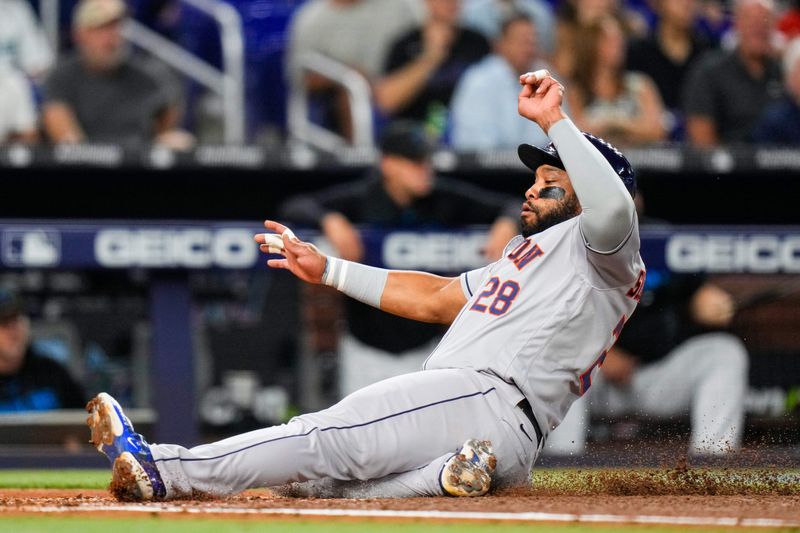 Aug 16, 2023; Miami, Florida, USA; Houston Astros first baseman Jon Singleton (28) slides into home base against the Miami Marlins during the first inning at loanDepot Park. Mandatory Credit: Rich Storry-USA TODAY Sports