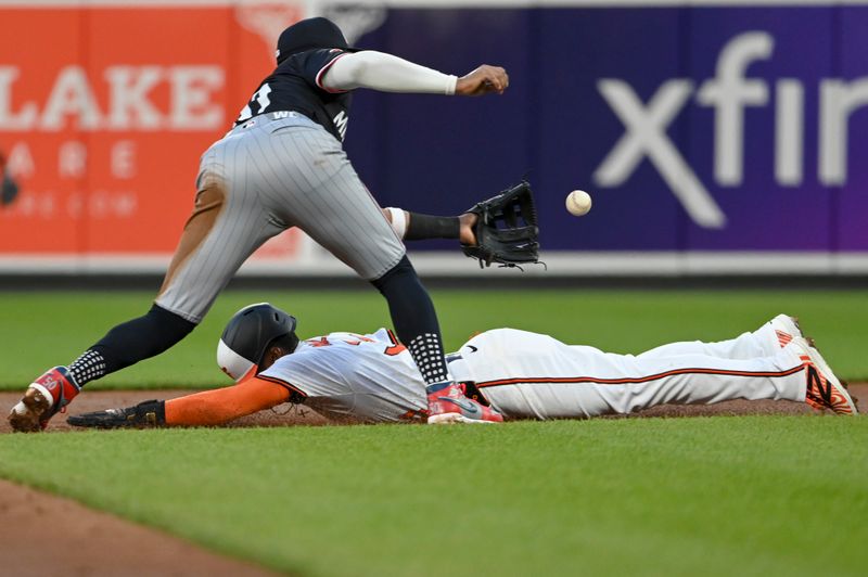 Apr 16, 2024; Baltimore, Maryland, USA;  Baltimore Orioles outfielder Cedric Mullins (31) slides under Minnesota Twins shortstop Willi Castro (50) tag attempt for a third inning stolen base at Oriole Park at Camden Yards. Mandatory Credit: Tommy Gilligan-USA TODAY Sports