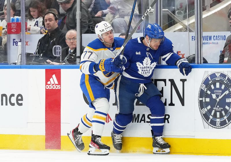 Mar 6, 2024; Toronto, Ontario, CAN; Toronto Maple Leafs center Max Domi (11) battles along the boards with Buffalo Sabres right wing JJ Peterka (77) during the first period at Scotiabank Arena. Mandatory Credit: Nick Turchiaro-USA TODAY Sports