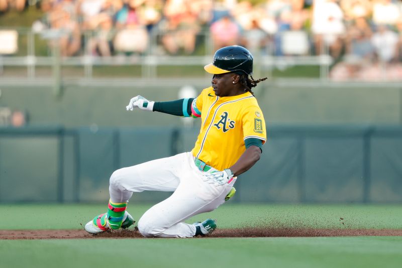 May 20, 2025; West Sacramento, California, USA; Athletics right fielder Lawrence Butler (4) slides into second base after hitting a double during the third inning against the Los Angeles Angels at Sutter Health Park. Mandatory Credit: Sergio Estrada-Imagn Images