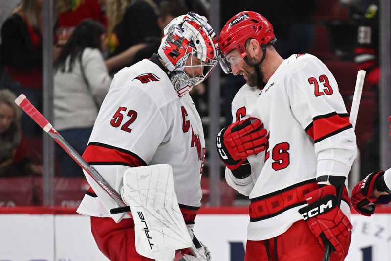 Apr 14, 2024; Chicago, Illinois, USA; Carolina Hurricanes goaltender Pyotr Kochetkov (52) and forward Stefan Noesen (23) celebrate after defeating the Chicago Blackhawks 4-2 at United Center. Mandatory Credit: Jamie Sabau-USA TODAY Sports