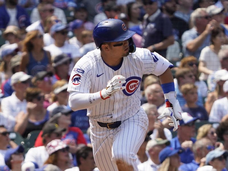 Aug 6, 2025; Chicago, Illinois, USA; Chicago Cubs designated hitter Seiya Suzuki (27) hits a one run sacrifice against the Cincinnati Reds during the third inning at Wrigley Field. Mandatory Credit: David Banks-Imagn Images