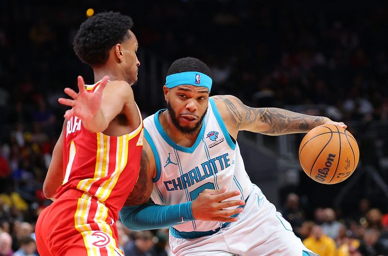 ATLANTA, GEORGIA - APRIL 10:  Miles Bridges #0 of the Charlotte Hornets drives against Kobe Bufkin #4 of the Atlanta Hawks during the fourth quarter at State Farm Arena on April 10, 2024 in Atlanta, Georgia.  NOTE TO USER: User expressly acknowledges and agrees that, by downloading and/or using this photograph, user is consenting to the terms and conditions of the Getty Images License Agreement.  (Photo by Kevin C. Cox/Getty Images)