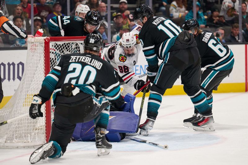 Mar 23, 2024; San Jose, California, USA; Chicago Blackhawks center Connor Bedard (98) extends for the puck against San Jose Sharks goaltender Devin Cooley (1) and center Luke Kunin (11) during the first period at SAP Center at San Jose. Mandatory Credit: Robert Edwards-USA TODAY Sports