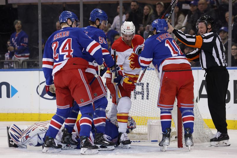 Feb 12, 2024; New York, New York, USA; Calgary Flames center Kevin Rooney (21) steps over New York Rangers goaltender Igor Shesterkin (31) as he pushes and shoves against Rangers right wing Kaapo Kakko (24) and left wing Will Cuylle (50) and center Vincent Trocheck (16) during the second period at Madison Square Garden. Mandatory Credit: Brad Penner-USA TODAY Sports